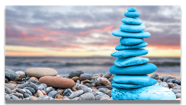 Auf dem Bild sehen wir einen im Blau des Corporate Designs eingefärbten Steinturm am Meeresstrand. Er symbolisiert das Ziel der Therapie für Übergänge und Änderungsprozesse: Beständigkeit und Balance, Bei-sich-Sein.